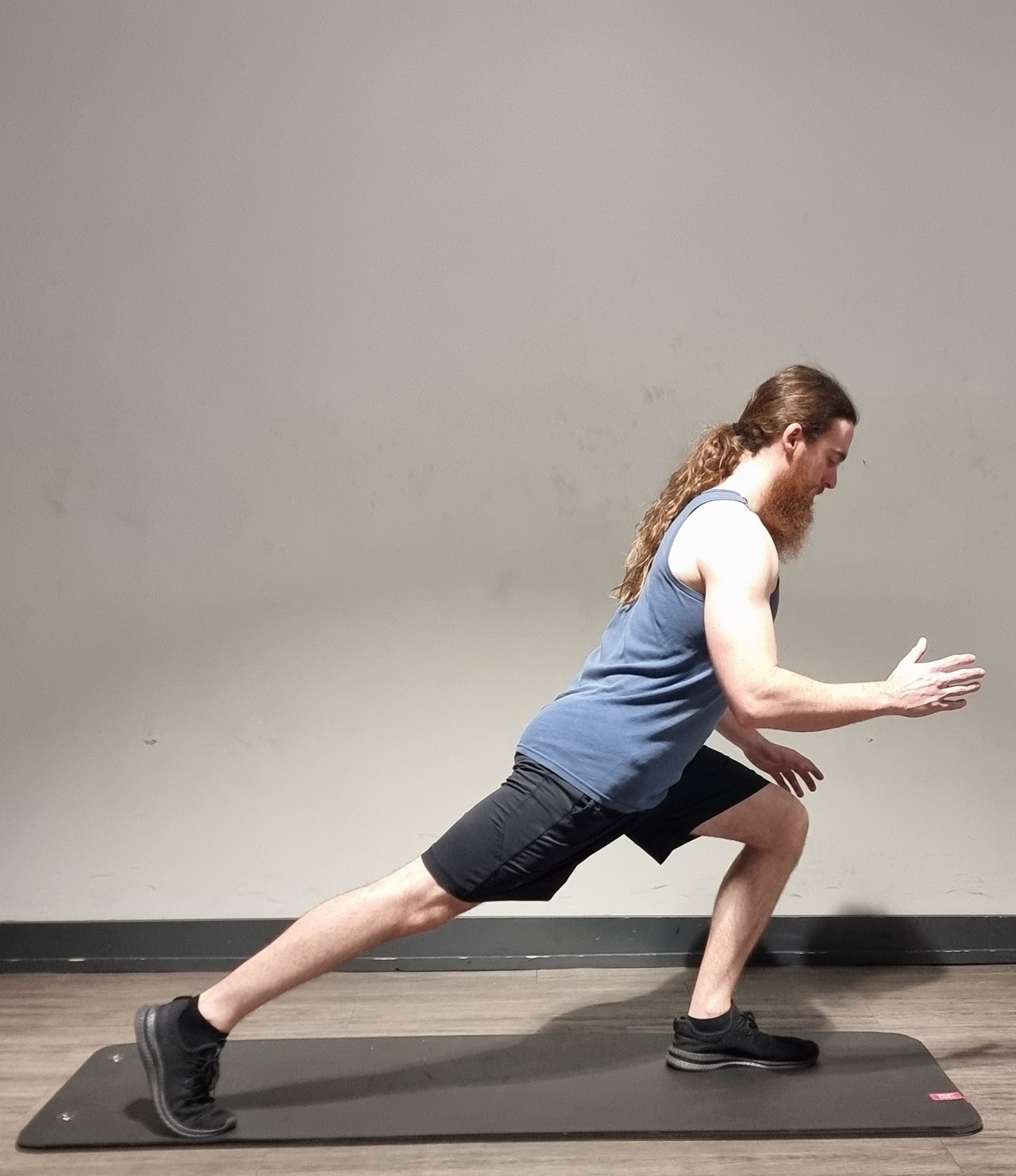 A man performing a reverse lunge with a long stride